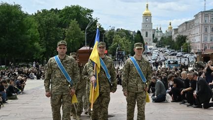 Des soldats ukrainiens accompagnent le cerceuil d'un militaire tombé au combat, le 19 juin 2025, à Kiev. (GENYA SAVILOV / AFP)