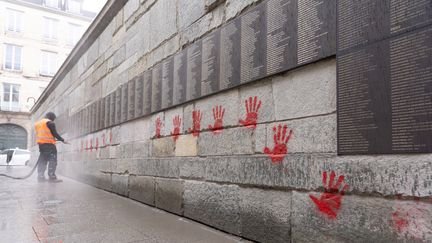 Un employé de la ville nettoie le mur des Justes du mémorial de la Shoah, le 14 mai 2024. (ANTONIN UTZ / AFP)